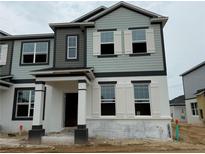 Charming two-story townhome featuring light blue and gray color scheme, white trim, and a covered entryway at 652 Pothos St, Apopka, FL 32703