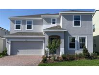 Charming two-story home boasts a well-maintained yard and attached two-car garage, enhancing curb appeal at 14746 Erice Ave, Clermont, FL 34714