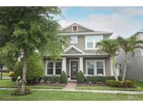 Charming two-story home with a well-manicured lawn, lush landscaping, and inviting front porch at 15849 Sweet Lemon Way, Winter Garden, FL 34787