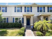Inviting townhouse featuring a covered entryway, blue shutters and landscaping at 16518 Brook Springs Aly, Winter Garden, FL 34787