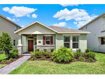 Inviting single-story home with well-manicured lawn, stone accents, and a charming covered entryway at 17847 Adrift Rd, Winter Garden, FL 34787