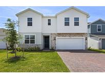 Charming two-story home with a brick paver driveway and a well-manicured lawn at 2055 Town Pasture Dr, Eustis, FL 32726