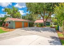Home exterior featuring a two-car garage, large driveway, and lush greenery surrounding the property at 3085 Vest Rd, St Cloud, FL 34772