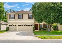 Charming two-story home with a three-car garage, lush landscaping, and a well-maintained front yard at 555 Carey Way, Orlando, FL 32825