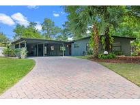 Charming home featuring a brick driveway, lovely yard, and inviting facade with a carport at 808 Denton Rd, Winter Park, FL 32792