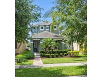 Charming two-story home featuring a well-manicured lawn and lush landscaping at 15160 Avenue Of The Arbors, Winter Garden, FL 34787
