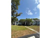 Three-story condo building with blue siding, mature trees, and well-maintained landscaping at 2585 Grassy Point Dr # 313, Lake Mary, FL 32746