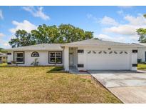 Charming single-story home featuring a two-car garage, well-maintained lawn, and modern architectural details at 3111 Pine Tree Dr, Edgewater, FL 32141