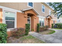 Charming townhouse featuring a stucco facade, well-maintained landscaping, and inviting front entrance at 3321 San Jacinto Cir # 116, Sanford, FL 32771