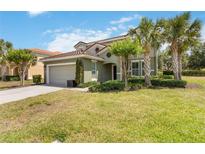 Charming two-story home with a tile roof and lush landscaping featuring mature palm trees at 4201 Oakview Dr, Davenport, FL 33837