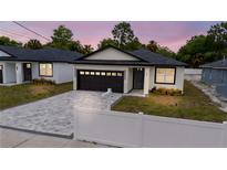 Charming single-story home with a gray brick driveway and a dark brown two-car garage at 59 W 10Th St, Apopka, FL 32703