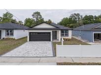 Charming single-story home with a gray brick driveway and a two-car garage at 59 W 10Th St, Apopka, FL 32703