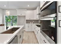 Modern kitchen featuring white cabinets, stainless steel appliances, and quartz countertops at 59 W 10Th St, Apopka, FL 32703