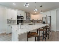Modern kitchen features a large island, stainless steel appliances, and stylish lighting fixtures at 59 W 10Th St, Apopka, FL 32703