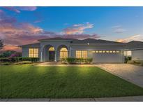 Charming home with manicured lawn and arched entry, illuminated by the warm glow of sunset at 409 Belfry Dr, Davenport, FL 33897