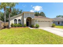 Charming single-story home featuring a well-manicured lawn and attached two-car garage at 830 Grand Hughey Ct, Apopka, FL 32712