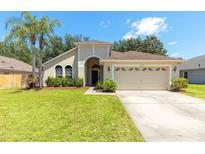 Charming single-Gathering home featuring a well-maintained lawn, a two car garage, and lush landscaping at 830 Grand Hughey Ct, Apopka, FL 32712