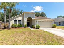 Charming single-story home featuring a manicured lawn and an attached two-car garage at 830 Grand Hughey Ct, Apopka, FL 32712