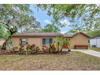Charming single-story home featuring a well-manicured front yard with lush landscaping and mature trees at 150 Debary Dr, Debary, FL 32713