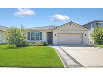 Charming single-story home featuring a well-manicured lawn, a two-car garage, and a welcoming front entrance at 1866 Cassidy Knoll Dr, Kissimmee, FL 34744