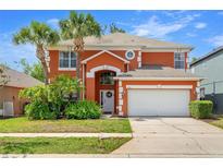 Charming two-story home featuring an attached two-car garage and well-manicured landscaping at 2769 Lido Key Dr, Kissimmee, FL 34747