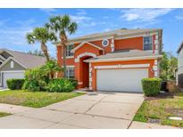 Charming two-story home featuring an attached two-car garage and mature landscaping at 2769 Lido Key Dr, Kissimmee, FL 34747