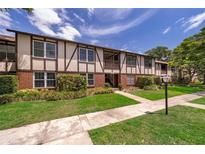 Inviting Tudor-style condo with well-manicured lawn and beautiful front walkway and manicured plants at 5325 Hansel Ave # E-15, Orlando, FL 32809
