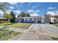 Charming single story home with a carport and a cozy screened in front porch and well-maintained front yard at 6464 Inca St, Orlando, FL 32807