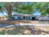 Charming single-story home featuring an attached garage, mature tree, and brick accents at 7507 Duo Lakes Dr, Orlando, FL 32810