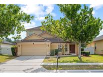 Two-story home featuring a well-manicured lawn, mature shade trees, and attached two-car garage at 802 Pickfair Ter, Lake Mary, FL 32746
