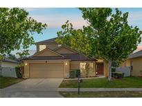 Two-story home featuring a well-manicured lawn, mature shade trees, and attached two-car garage at 802 Pickfair Ter, Lake Mary, FL 32746