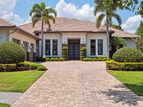 Stunning home exterior featuring a brick driveway, manicured landscaping, and a modern design at 8581 Lake Nona Shore Dr, Orlando, FL 32827