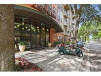 Welcoming entrance to Uptown Place, featuring glass doors, landscaping, and convenient golf cart parking at 911 N Orange Ave # 409, Orlando, FL 32801