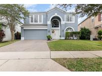 Charming two-story home featuring an arched entry, attached garage, and well-maintained landscaping at 12651 Winding Woods Ln, Orlando, FL 32832