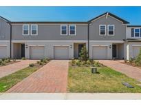 Charming townhome exterior with a brick walkway, well-kept lawn and a one car garage at 16419 Bird Of Paradise Ave, Clermont, FL 34714