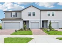 Charming exterior view of a newly built townhouse with light gray siding and a well-manicured front lawn at 16434 Bird Of Paradise Ave, Clermont, FL 34714