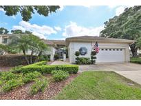Charming one-story home featuring a tile roof, manicured landscaping, and a two-car garage at 2446 Sweetwater Country Club Dr, Apopka, FL 32712