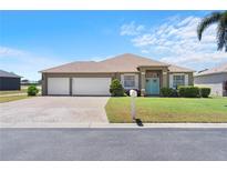 Charming single-story home with a well-manicured lawn, three-car garage, and welcoming entryway at 829 Terranova Rd, Winter Haven, FL 33884