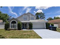 Charming two-story home with a well-maintained front yard and attached two car garage at 8347 Willowwood St, Orlando, FL 32818