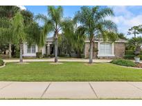 Charming, stone-accented home featuring a meticulously maintained lawn and mature palm trees at 1091 Hampstead Ln, Ormond Beach, FL 32174