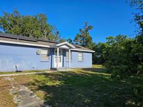 Charming blue home featuring a covered entryway and lush landscaping under a sunny, clear sky at 15 Estrella Rd, Debary, FL 32713