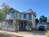 Charming two-story home with a welcoming porch and a well-maintained front yard with beautiful landscaping at 209 E 4Th St, Sanford, FL 32771