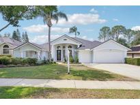 Charming single-story home with a well-manicured lawn, a three-car garage and a welcoming front entrance at 336 Plantation Club Dr, Debary, FL 32713
