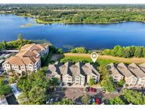 A scenic aerial view of the condo community on the lake with well maintained landscaping and common areas at 3480 Soho St # 107, Orlando, FL 32835