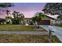 Charming single-story home featuring a well-manicured lawn and beautiful tropical landscaping at 1026 Manchester Cir, Winter Park, FL 32792