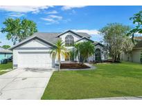 Charming two-story home featuring a well-manicured lawn, mature trees, and a spacious two-car garage at 11160 Sylvan Pond Cir, Orlando, FL 32825