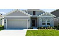 Charming single-story home with a well-maintained lawn, neutral paint, and an attached two-car garage at 1163 James Paul Rd, Davenport, FL 33837
