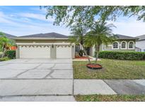 Charming single-Gathering home featuring a three-car garage, landscaped yard, and mature trees at 339 Hammock Dunes Pl, Orlando, FL 32828