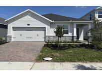Charming single-story home featuring a two-car garage and a well-manicured front yard at 5268 Teirgarten St, St Cloud, FL 34771