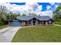 Charming brick home featuring a spacious front lawn and a two-car garage at 810 Alex Ln, Deltona, FL 32738